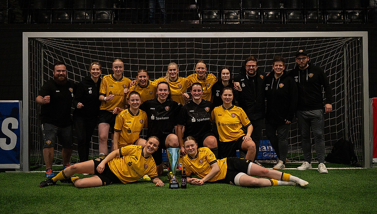 Das Team der Dynamo-Frauen zum Gruppenfoto mit Pokal in einem Fußball-Hallentor.