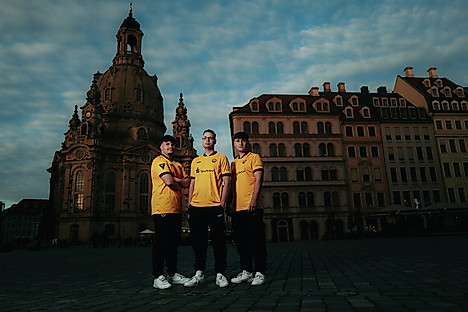 Drei Männer im Dynamo Trikot vor der Dresdner Frauenkirche in der Abenddämmerung