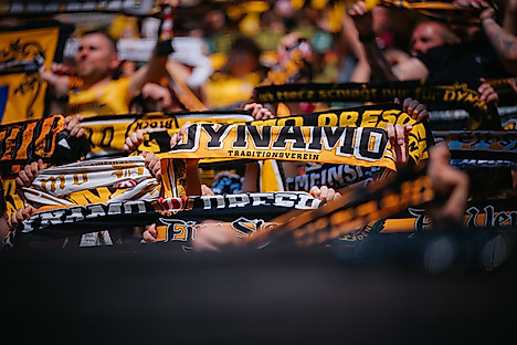 Fans halten einen SGD-Schal nach oben.