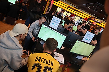 Teilnehmer, die beim Turnier vor der Konsole sitzen und EA FC spielen.
