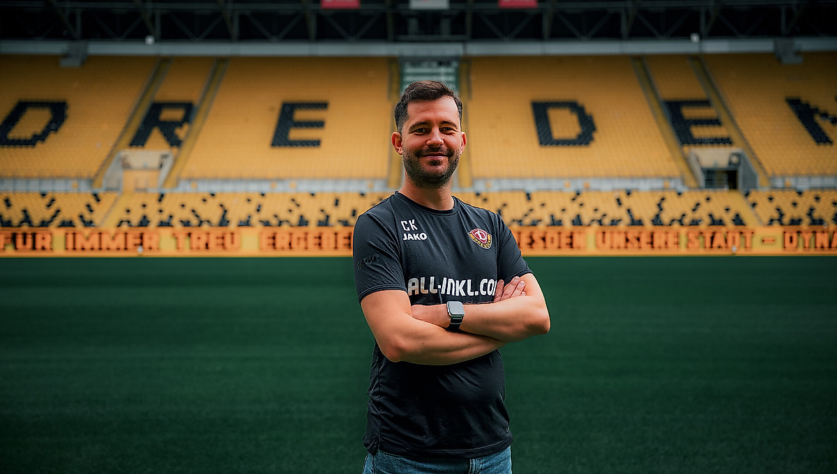 Dynamos Leiter für den Lizenzbereich steht mit verschränkten Armen im leeren Stadion.