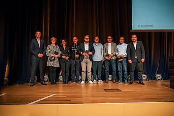 Gruppenfoto aus neun Personen.