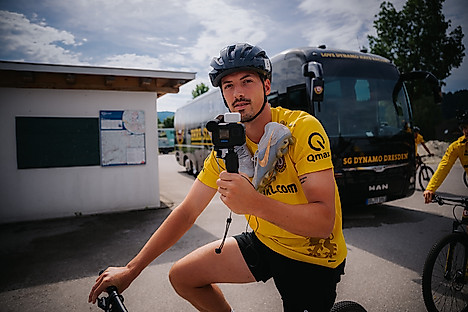 Nicolai Rapp mit der Kamera in der Hand auf dem Fahrrad.
