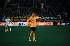 Aljaz Casar im gelben Dynamo-Trikot auf dem Spielfeld.