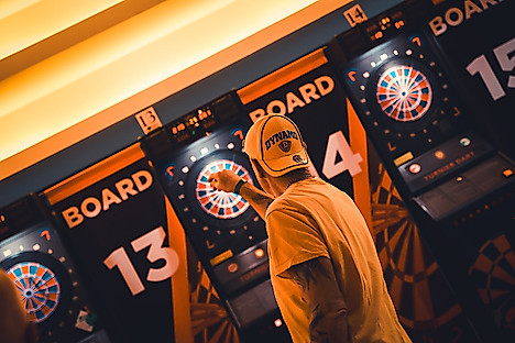 Ein Dynamo-Fan wirft einen Pfeil auf eine Dartscheibe.