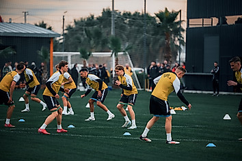 Die Spieler machen sich auf dem Rasen warm.