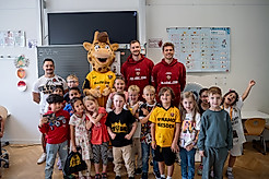 Eine Schulklasse beim Gruppenbild mit Spielern der SGD