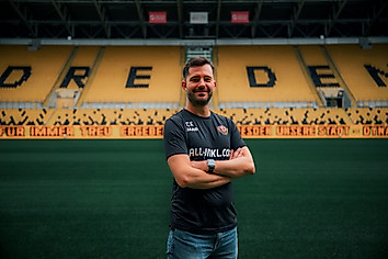 Dynamos Leiter für den Lizenzbereich steht mit verschränkten Armen im leeren Stadion.